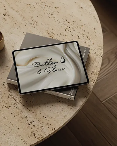 Butter and Glow branded tablet flatlay on a wooden surface
