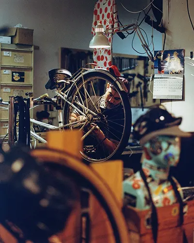 Bike workshop with man tuning a bike wheel